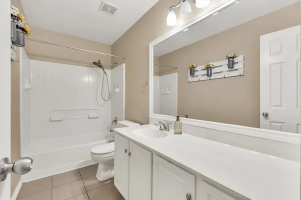 a bathroom with a double vanity sink toilet and shower