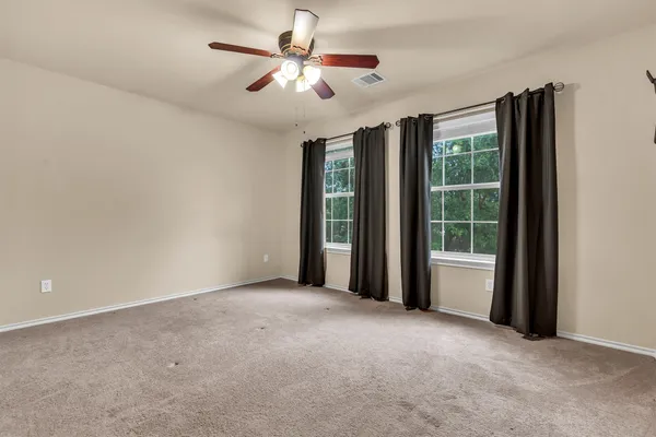 a view of a big room with windows and chandelier fan