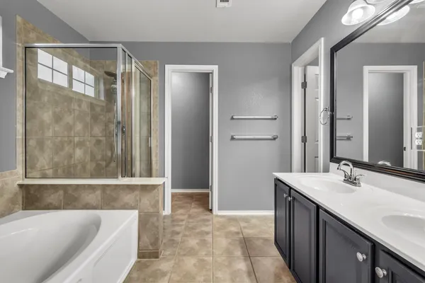 a bathroom with a tub sink and mirror