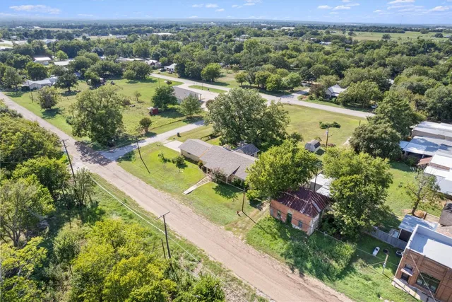 an aerial view of residential houses with outdoor space and street view
