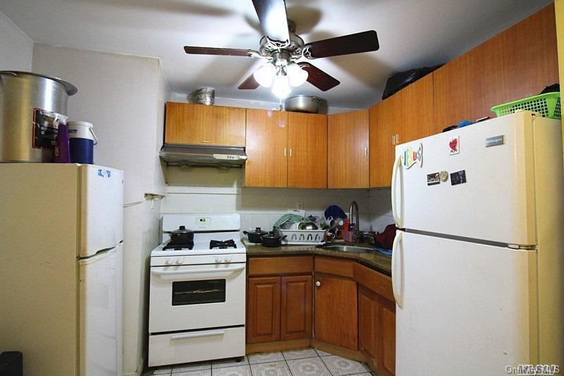 104-48 38th Avenue Queens, NY 11368 - Photo 2 of 9 a kitchen with a refrigerator a stove a sink and a refrigerator