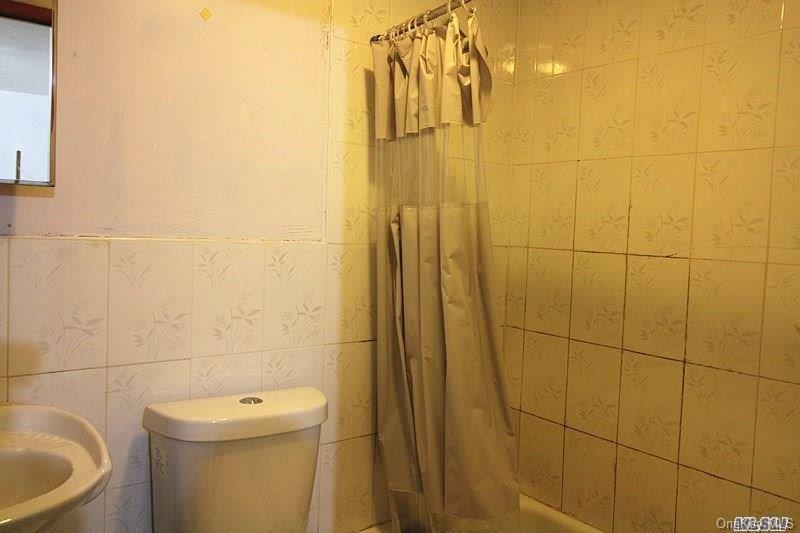 104-48 38th Avenue Queens, NY 11368 - Photo 5 of 9 a bathroom with a toilet and a shower