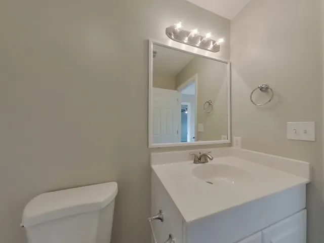 a bathroom with a sink a toilet and a mirror