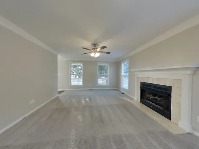 a view of empty room with fireplace and fan
