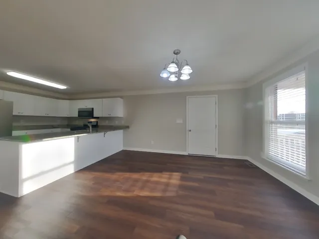 a view of kitchen with a sink wooden floor and a window