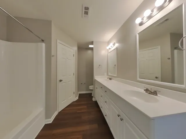 a bathroom with a double vanity sink and a mirror