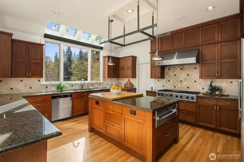 a kitchen with stainless steel appliances granite countertop a stove a sink dishwasher and a refrigerator