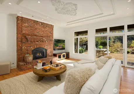 a living room with furniture a fireplace and a floor to ceiling window