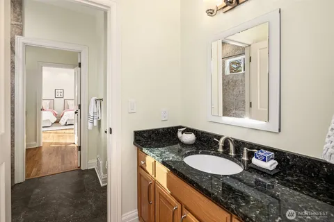 a bathroom with a granite countertop sink a mirror and a shower