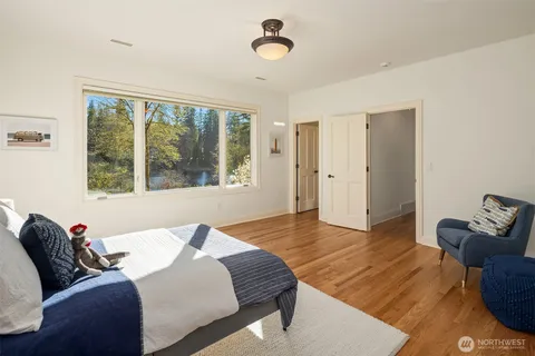 a bedroom with a bed and wooden floor