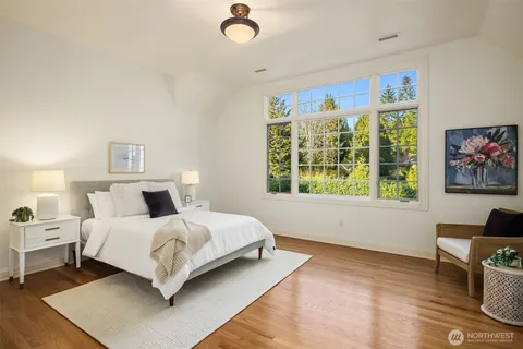 a spacious bedroom with a bed a couch and a window