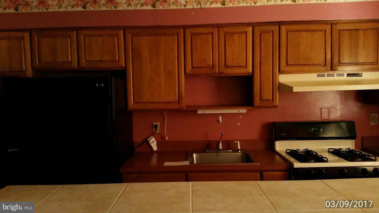 422 Scarsdale Road Baltimore, MD 21224 - Photo 7 of 7 a kitchen with wooden cabinets and a sink