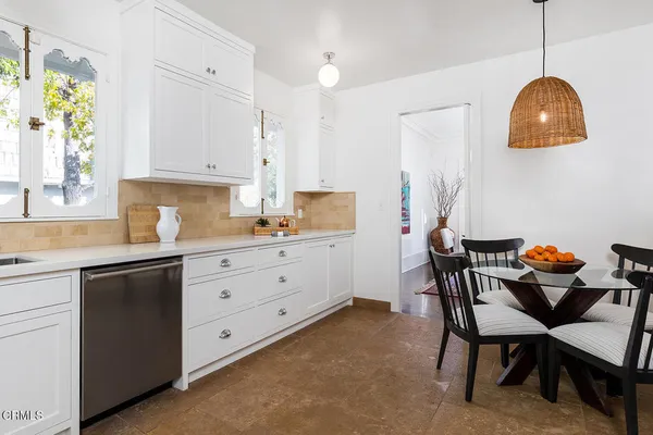 a kitchen with a sink a stove a dining table and chairs
