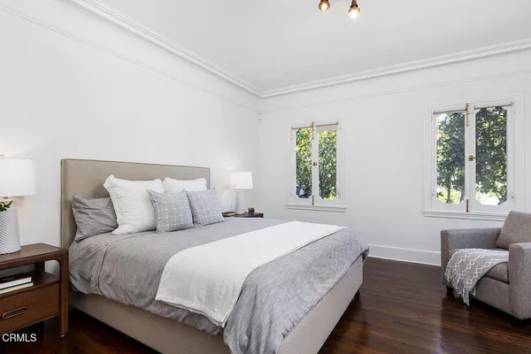 a bedroom with bed couch and window