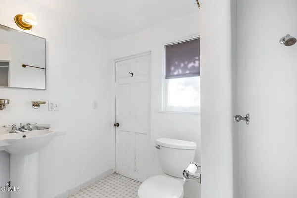 a bathroom with a toilet a sink and mirror