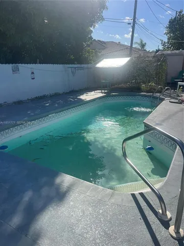 a view of a patio with table and chairs under an umbrella