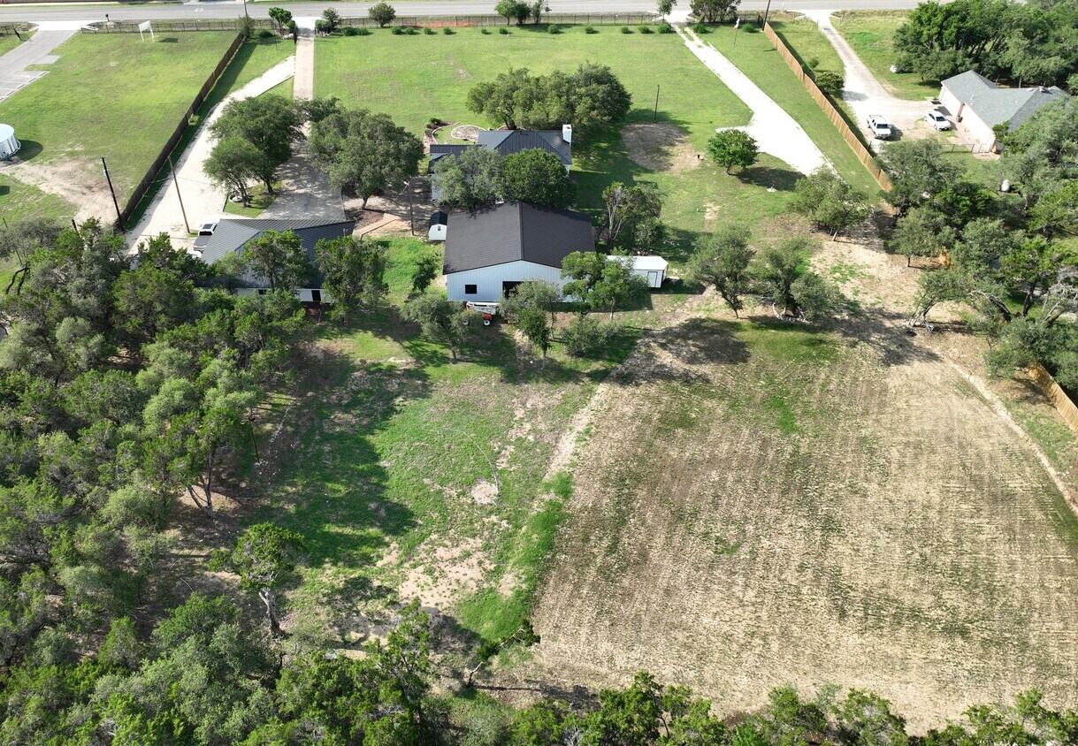 102 County Road 180 Leander, TX 78641 - Photo 9 of 25 An aerial perspective reveals a secluded estate nestled among verdant trees with a private driveway.