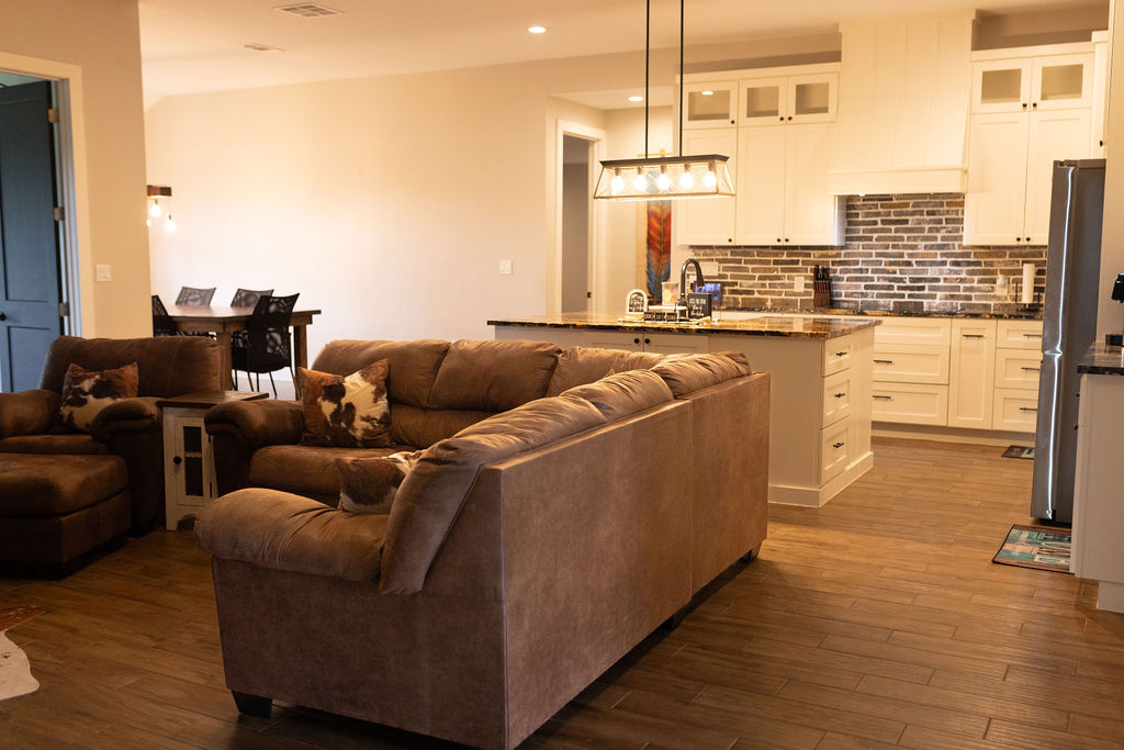 111 Powder Ridge Luling, TX 78648 - Photo 4 of 22 An inviting open-concept living space features a functional kitchen island and warm wood-look flooring.