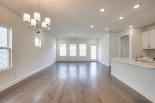 a view of a kitchen with a refrigerator wooden floor and a window