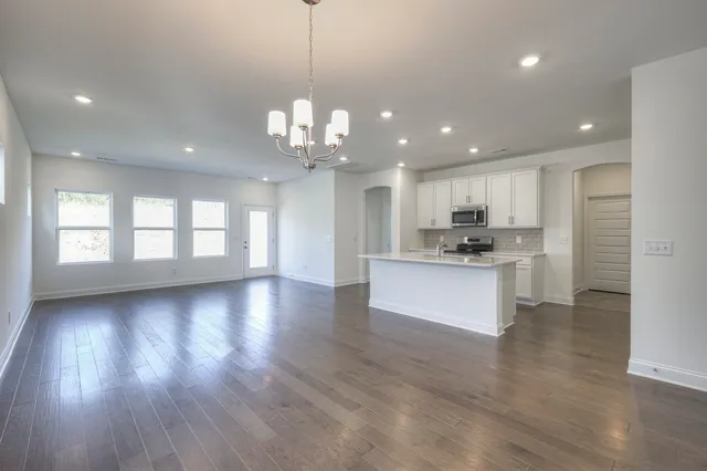 a view of kitchen with kitchen island wooden floor center island and stainless steel appliances