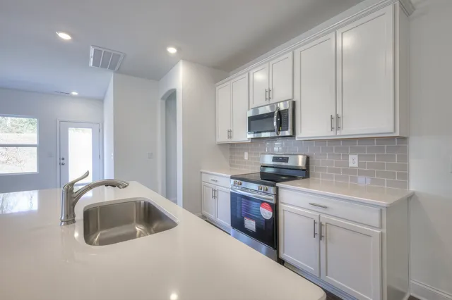 a kitchen with a sink and wooden floor