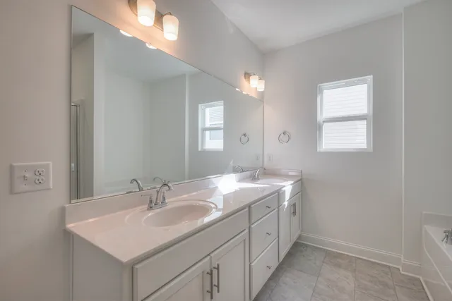 a bathroom with a granite countertop sink a mirror and shower