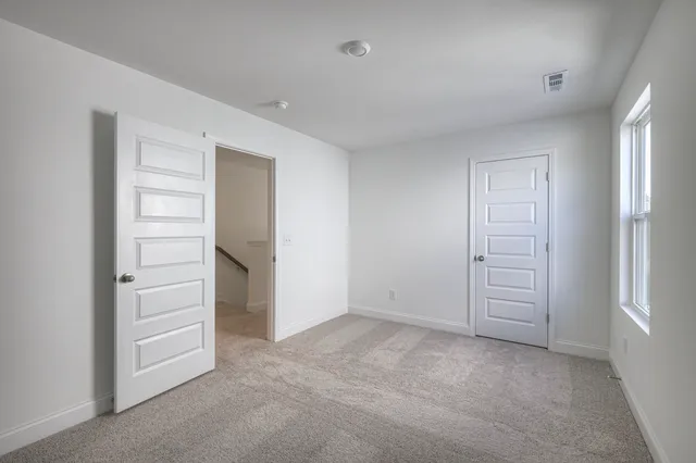 an empty room with a hallway and closet