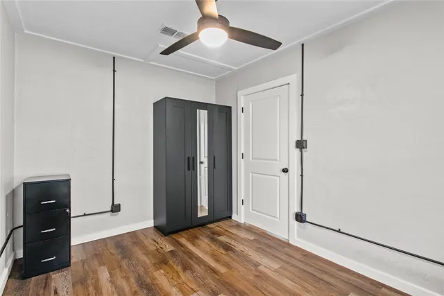 a view of empty room with wooden floor