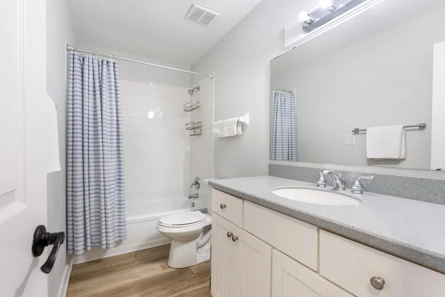 a bathroom with a granite countertop sink toilet a mirror and shower