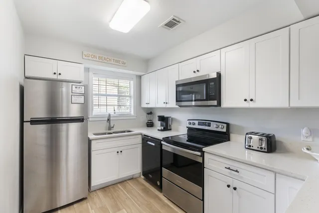 a kitchen with a refrigerator sink and cabinets