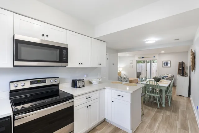 a kitchen with stainless steel appliances a stove a sink cabinets and a microwave