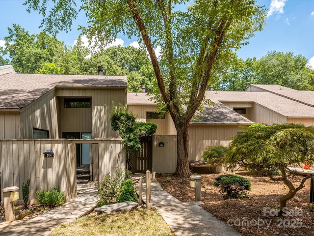 a white house that has a tree in front of it