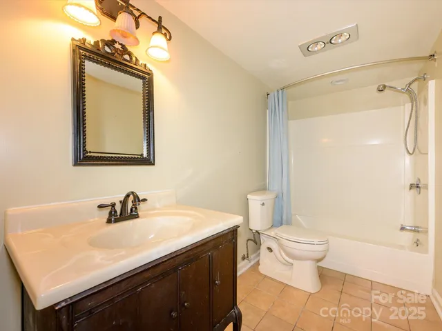 a view of an empty room with wooden floor and windows