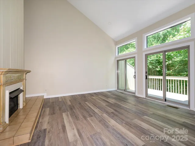 a view of a livingroom with wooden floor and a fireplace