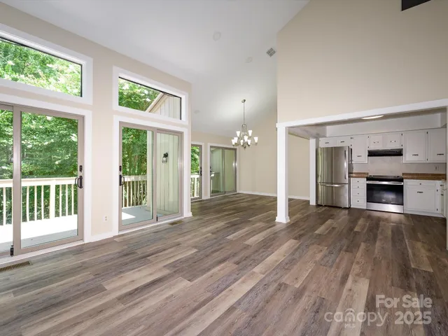 a view of kitchen with granite countertop cabinets stainless steel appliances and a ceiling fan