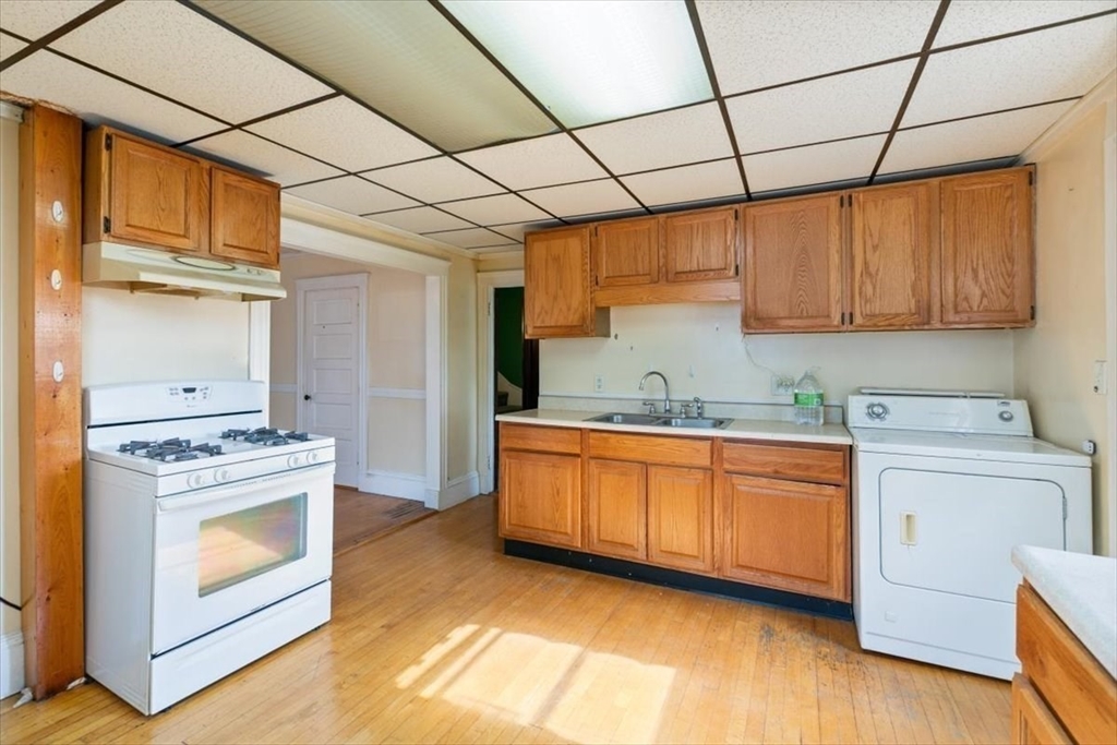 98 Webster Street Haverhill, MA 01830 - Photo 25 of 42 a kitchen with granite countertop a stove top oven sink and cabinets