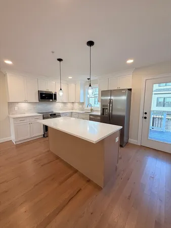 a large kitchen with stainless steel appliances granite countertop a stove a sink and a refrigerator