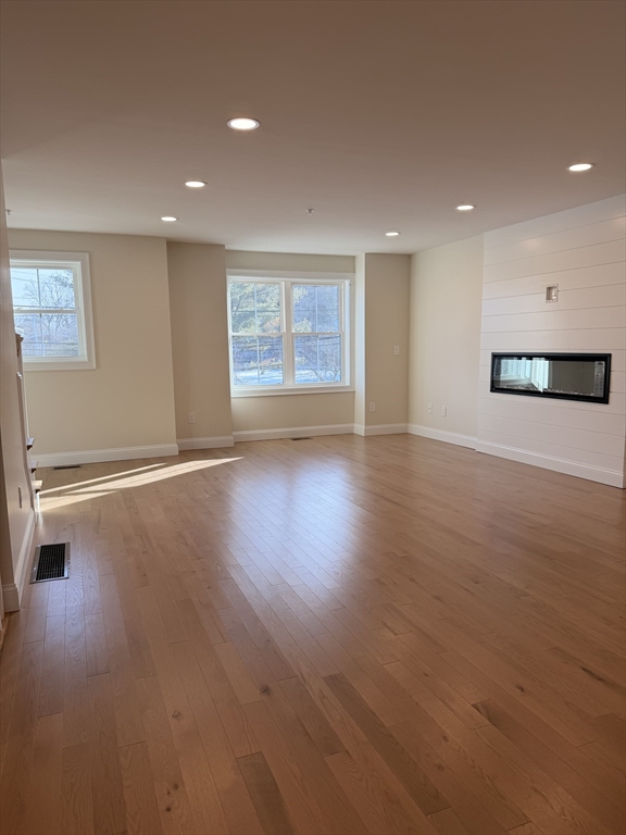 9 Acton Road, Unit 8 Chelmsford, MA 01824 - Photo 2 of 12 an empty room with wooden floor and windows