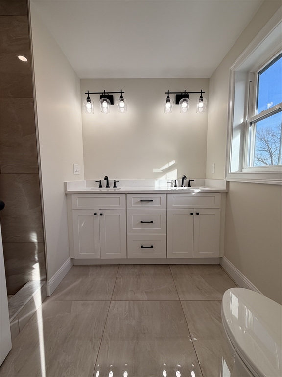 9 Acton Road, Unit 8 Chelmsford, MA 01824 - Photo 4 of 12 a bathroom with a sink a toilet and mirror