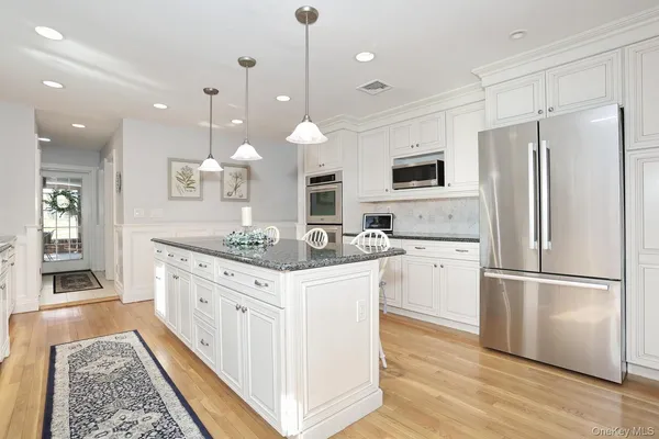 a kitchen with kitchen island a sink stainless steel appliances and cabinets