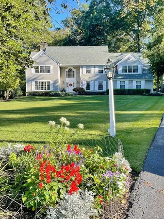 a front view of a house with a garden and swimming pool