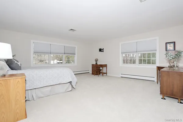 an empty room with windows and chandelier fan