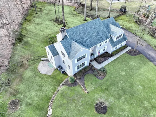 a front view of a house with a garden and trees