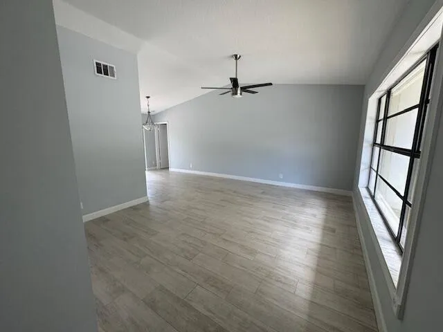 a view of a hallway with wooden floor and a window