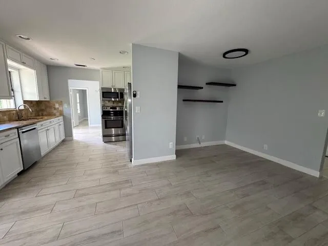 a view of a kitchen with a sink and a refrigerator