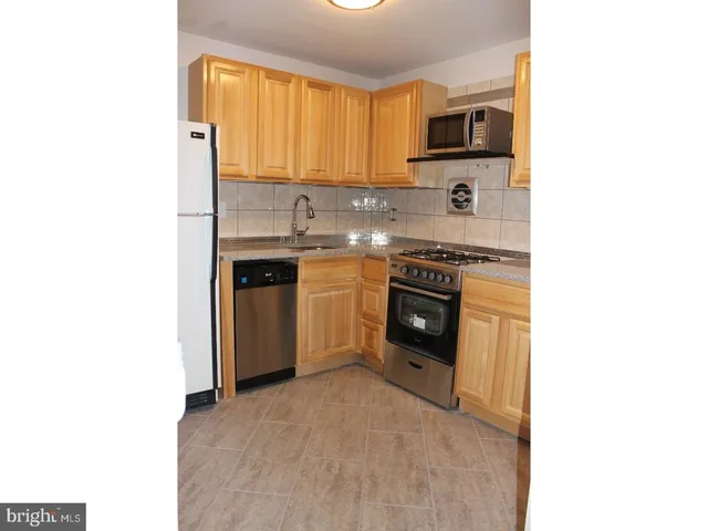 a kitchen with stainless steel appliances a stove sink and cabinets