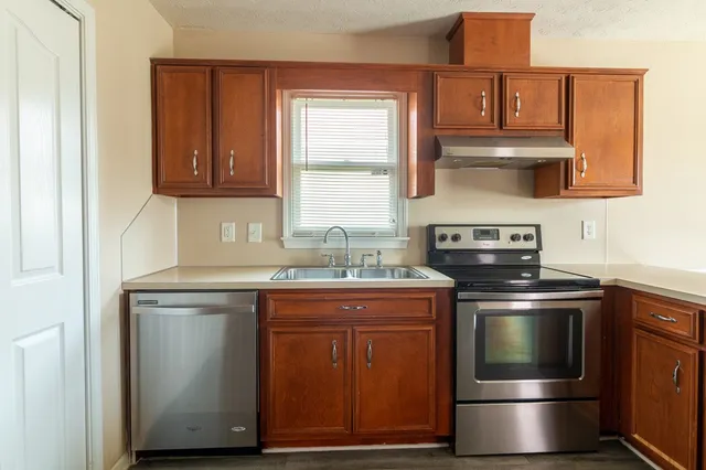 a kitchen with stainless steel appliances granite countertop a stove and a sink