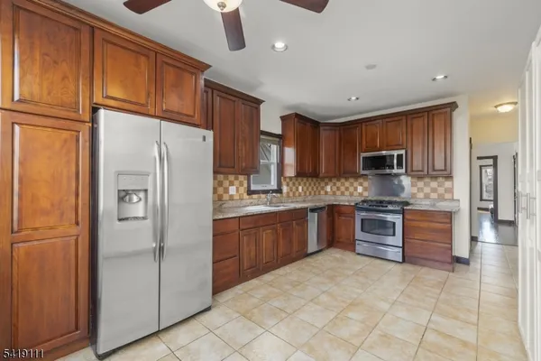a kitchen with stainless steel appliances granite countertop a refrigerator sink and cabinets