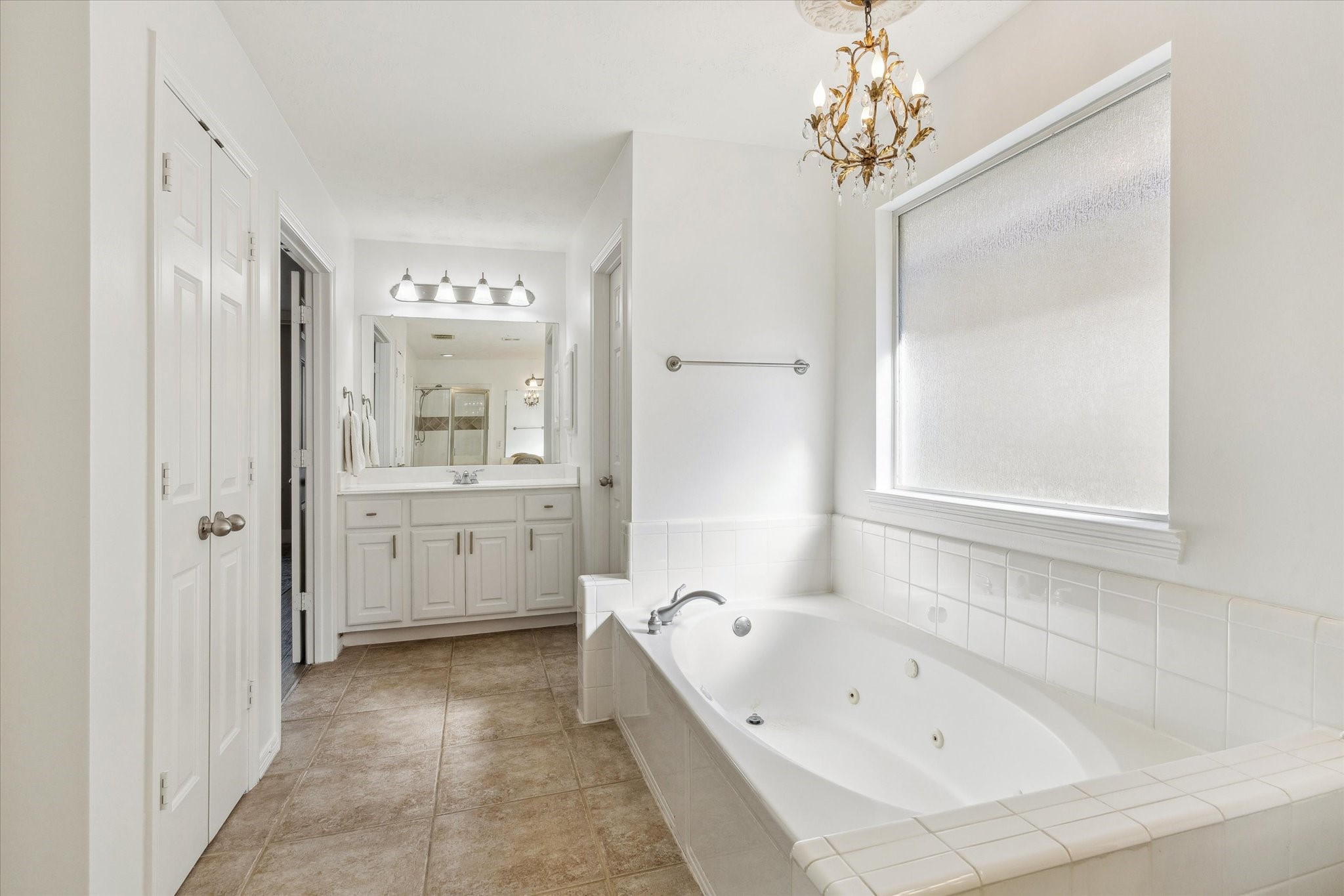5242 Eigel Street Houston, TX 77007 - Photo 19 of 29 This bright and elegant primary bathroom features a large soaking tub with tile surround, a spacious vanity with dual sinks.