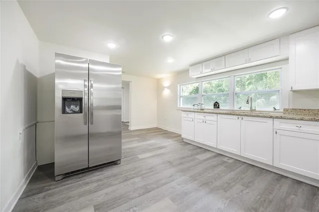 a kitchen with stainless steel appliances granite countertop a refrigerator and a sink